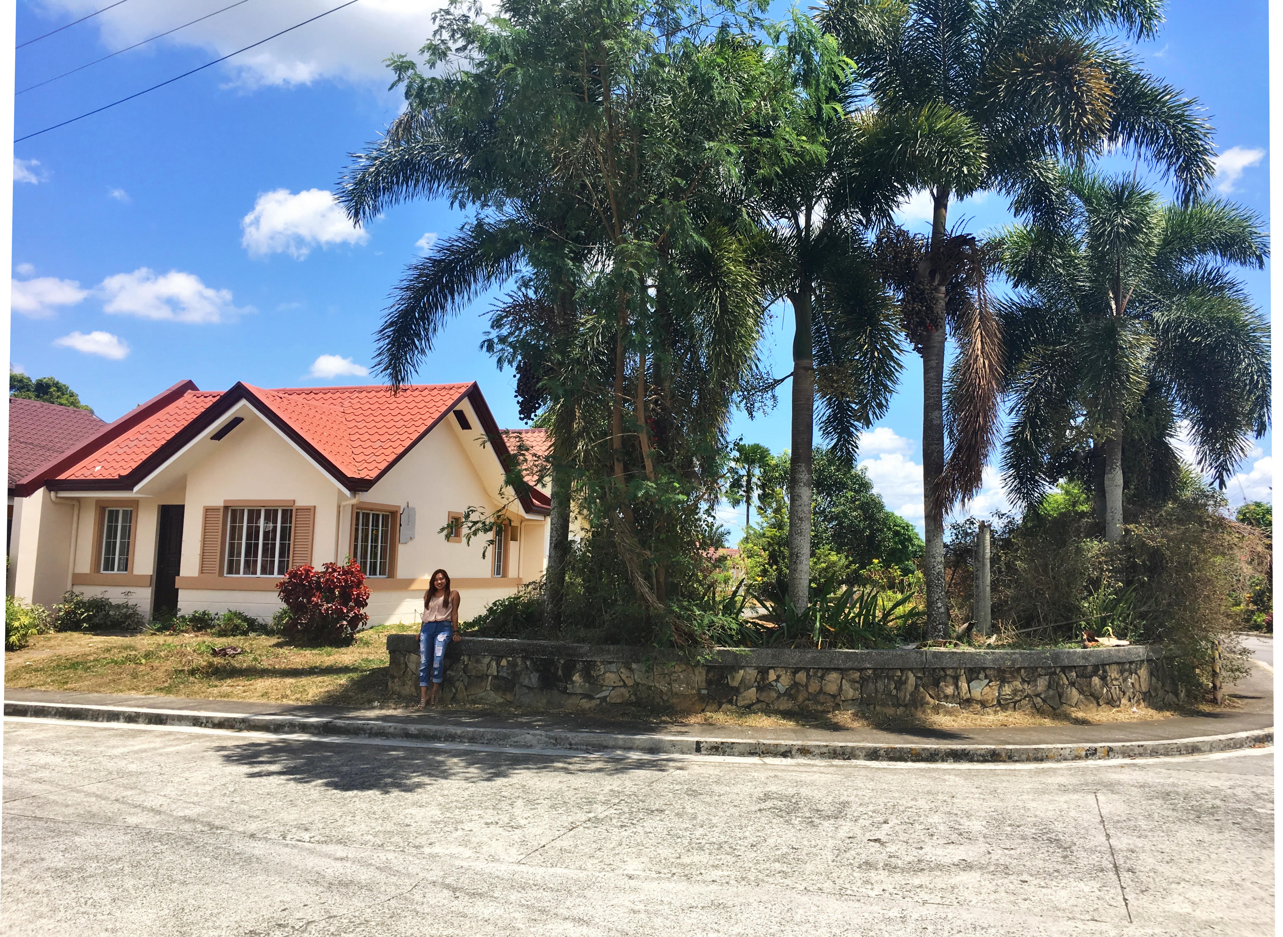 house and woman beside trees